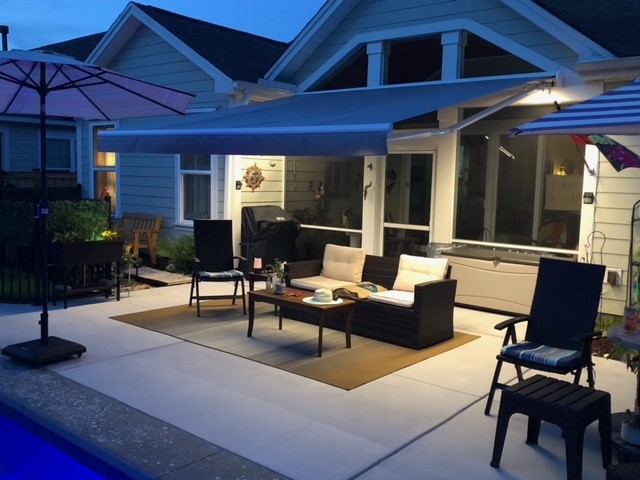 Motorized awning with LED lighting over a luxury patio at dusk