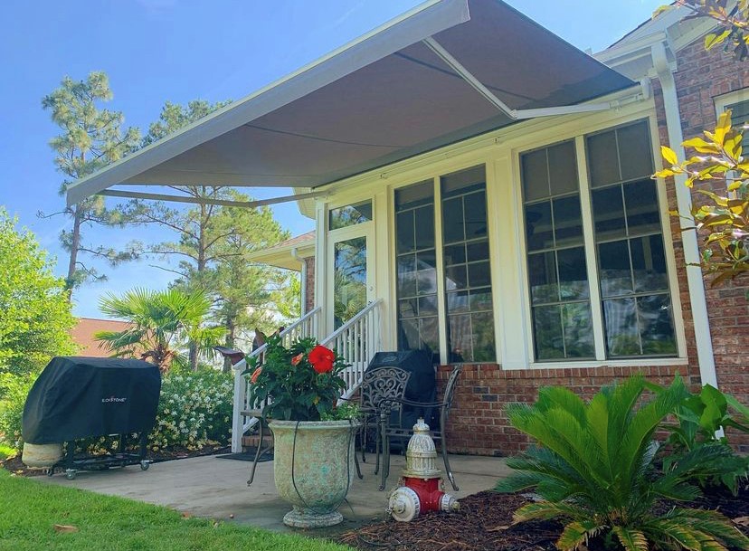 Gray retractable awning on a brick home